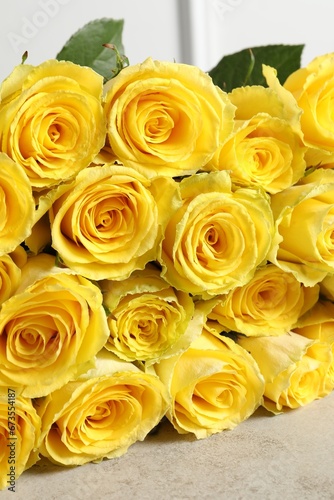 Beautiful bouquet of yellow roses on light grey table  closeup