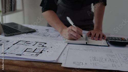 Engineer or architect working and calculations on paperworks blueprints construction drawings for structure for interior for houses and buildings. photo