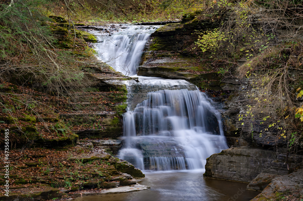 Obraz premium Afternoon fall, autumn photo of a waterfall in Robert H. Treman State Park near Ithaca NY, Tompkins County New York. 