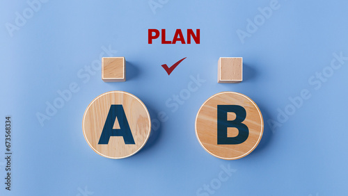 Checking the PLAN A or B on wooden blocks with the words Plan A and B on a blue background. photo