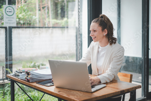 Beautiful business woman using laptop while sitting at her working place. Concentrated at work..