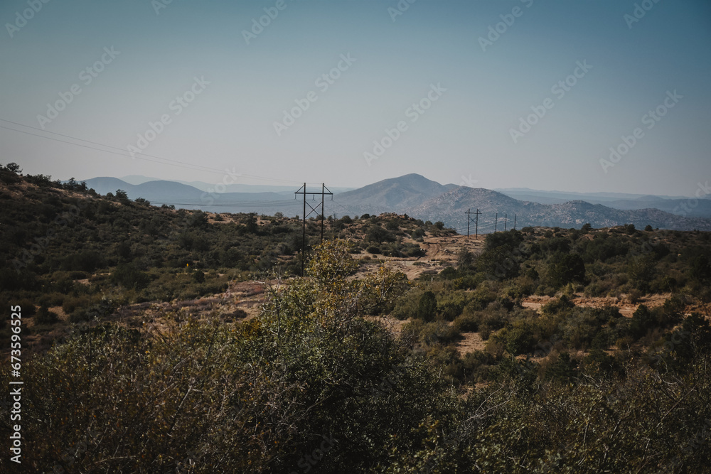 Landscape view of telephone poles through dry desert hillsides near Prescott Arizona in Granite Mountains