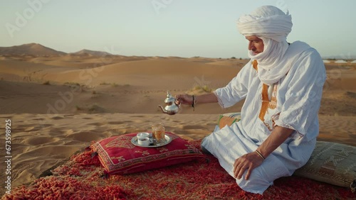 Berber man preparing the traditional moroccan tea in the desert, Morocco