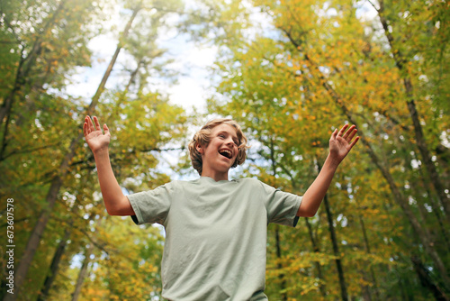 Happy Teen Boy Smiling as He Hikes in the Autumn Woods photo