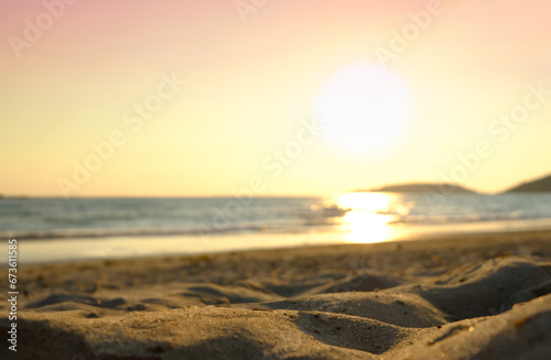 Beach sand background for summer vacation concept. The nature of the beach and the summer sea with the soft sunlight hitting the sand. The sea sparkles against the sunset sky. photo