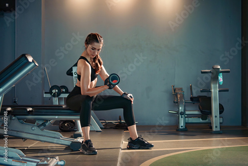 Fitness asian woman doing exercise and lifting dumbbells weights at sport gym.