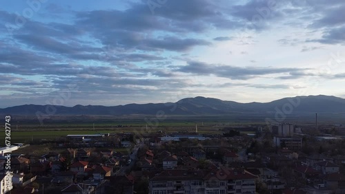 Beautiful establishing drone shot footage - flying over the typical Bulgarian small town, Sopot,looking towards 'Sredna gora' mountain and the fields before it photo