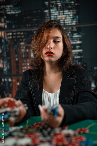 female player counts chips for money and raises bet while playing poker in casino. gambling concept