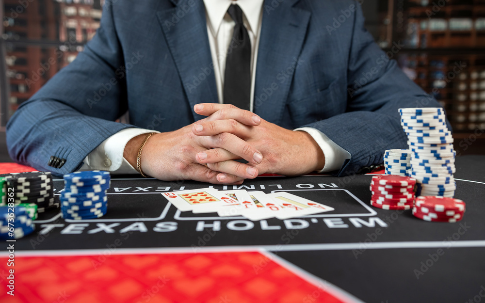 Man in suit hold card and chips play poker at casino Man in suit hold card and chips play poker at casino