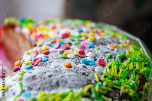 A cake with sprinkles on it is decorated with colorful sprinkles.