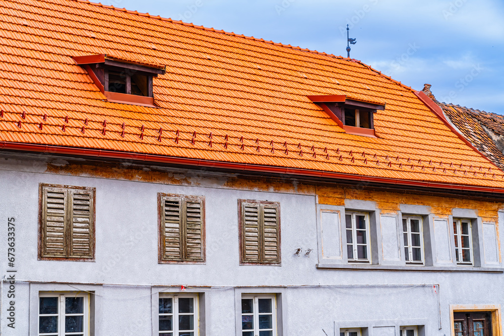 A white building with a red roof and windows. A Stunning White Building with a Vibrant Red Roof and Elegant Windows