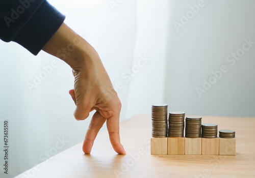 business and finance growth concept. Fingers walking up on coins stack and row of coin. collecting money, financial planning, save money for the future. photo