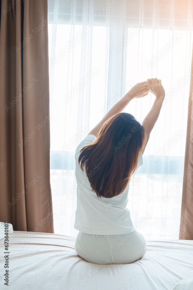 happy woman stretching on bed after wake up, young adult female rising arms and looking to window in the early morning. fresh relax and have a nice day concepts happy woman stretching on bed after wake up, young adult female rising arms and looking to window in the early morning. fresh relax and have a nice day concepts