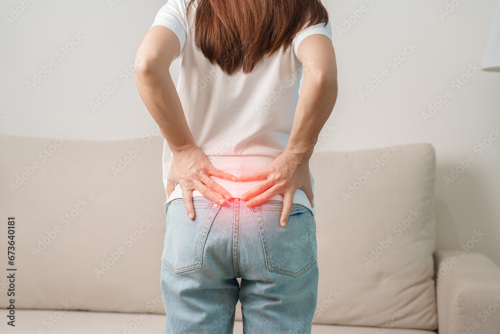 woman having back body ache during sitting on Couch at home. adult