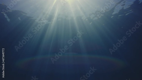 Sun rays in blue water, waves on the water surface, abstract photo