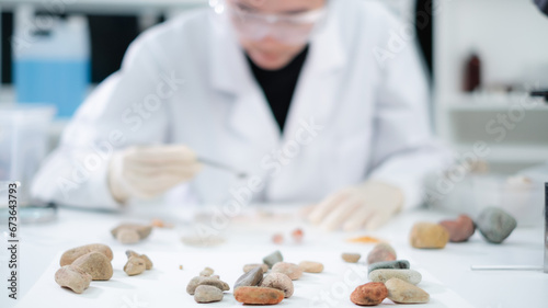 Tableau sur toile A female geologist or archaeologist is analyzing a sample of rock or mineral in paleontology, archaeological and geological or mining laboratory