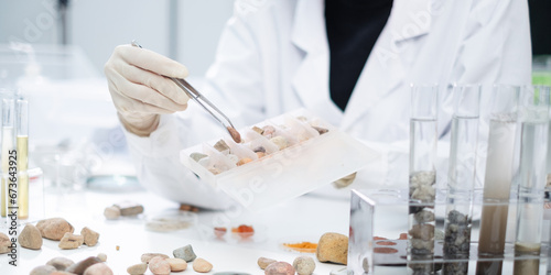 Photos Close up of geologist or archaeologist is selecting and choosing sample of rock, stone or mineral in paleontology, archaeological and geological or mining laboratory