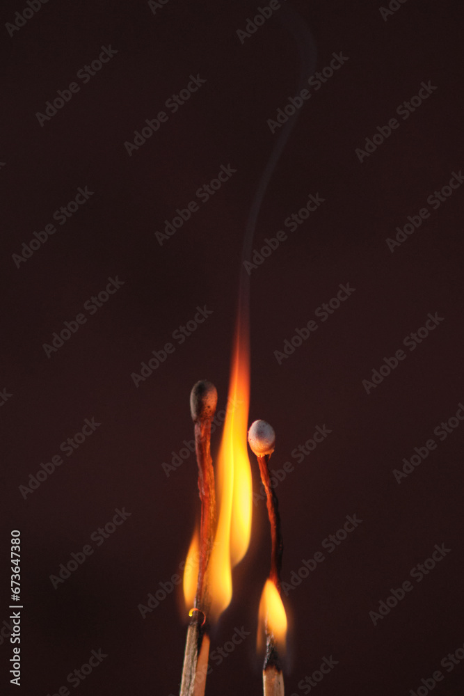 two lighted matches on a dark background two lighted matches on a dark background