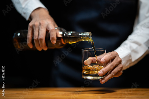 Barman pouring whiskey whiskey glass..