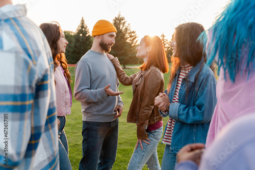 Portrait smiling friends wearing stylish colorful clothes, meeting, talking, outdoors, team building