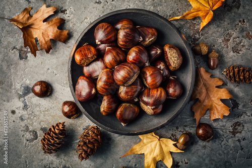 Foto Organic sweet chestnuts in a bowl on kitchen table
