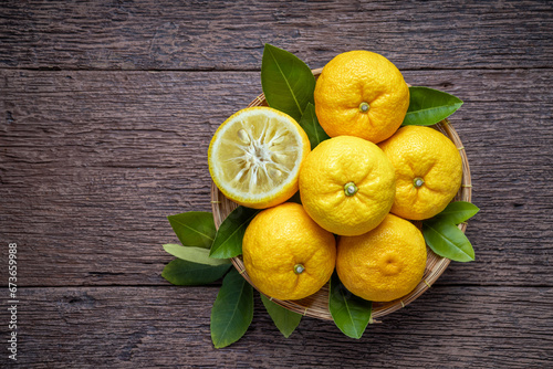 Fresh Sweet Yuzu Orange fruit in wooden basket over wooden background  Yuzu Orange fruit  Citron citrus on wooden background.