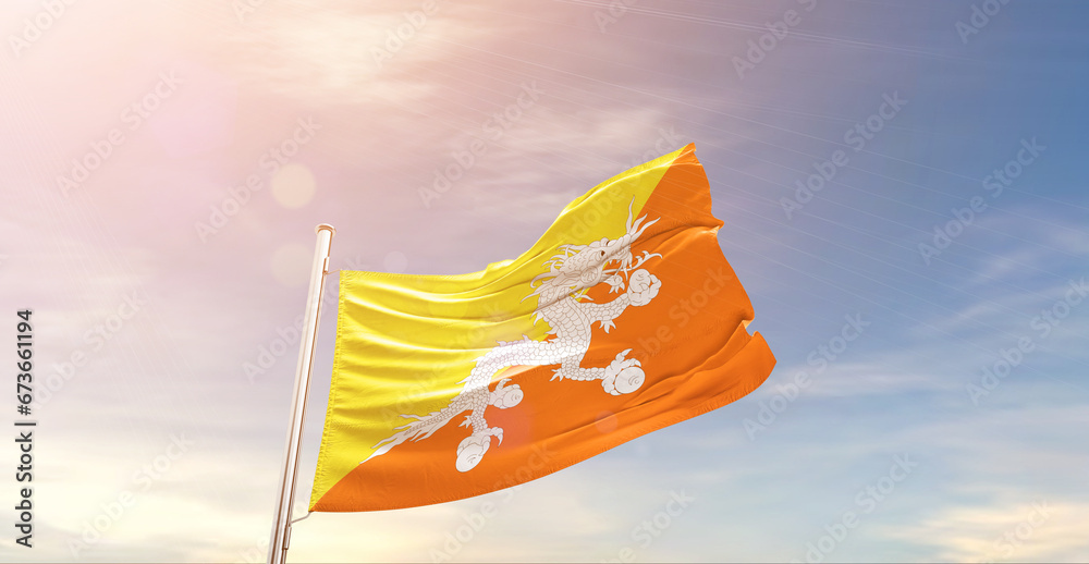 Bhutan national flag waving in beautiful sky. The symbol of the state on wavy silk fabric.