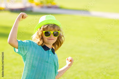 Excited kids in hat and summer sunglasses. Lifestyle portrait of cute kid outdoors. Summer kids outdoor portrait. Little winner gesture win.