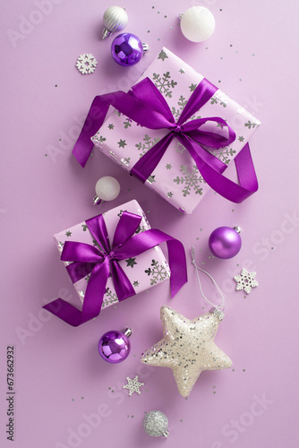 Celebrate joyously with vertical top view of lilac gift boxes  gleaming baubles  vibrant stars  and snowy decor on a purple backdrop. Perfect for advertisements