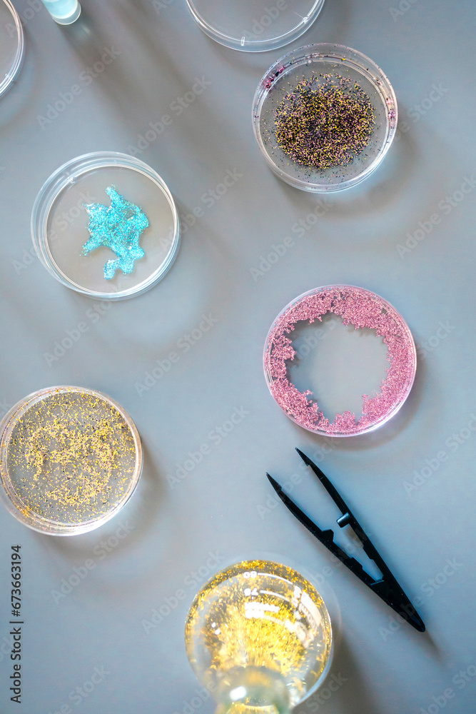 Top view of different glitter samples in petri dishes over a lab table ...