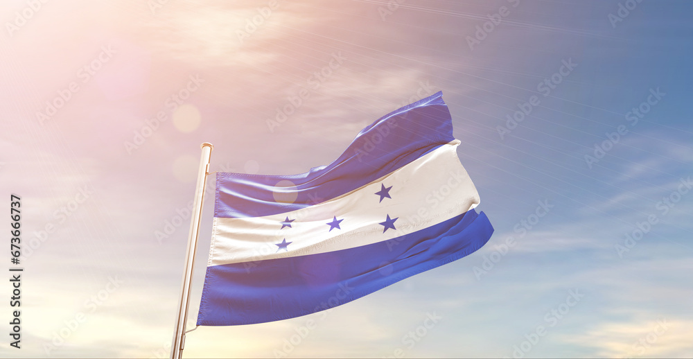 Honduras national flag waving in beautiful sky. The symbol of the state on wavy silk fabric.
