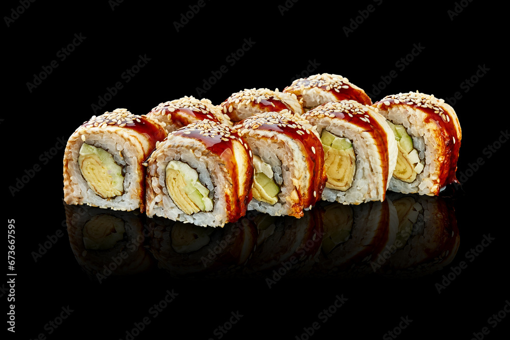 Sushi roll with eel, omelet, cream cheese on a black background. Close-up