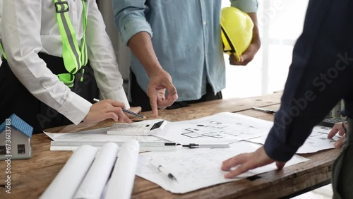 Civil engineering team meeting Along with the architect and the foreman watching the blueprints and planning the construction of the building in the real estate industrial concept construction site.