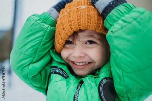 Happy boy wearing yellow knit hat in winter photo