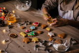 A close-up of the process of making New Year's gingerbread cookies in an atmospheric kitchen at home. Christmas mood. Recipe for New Year's treats. Cookie coloring process