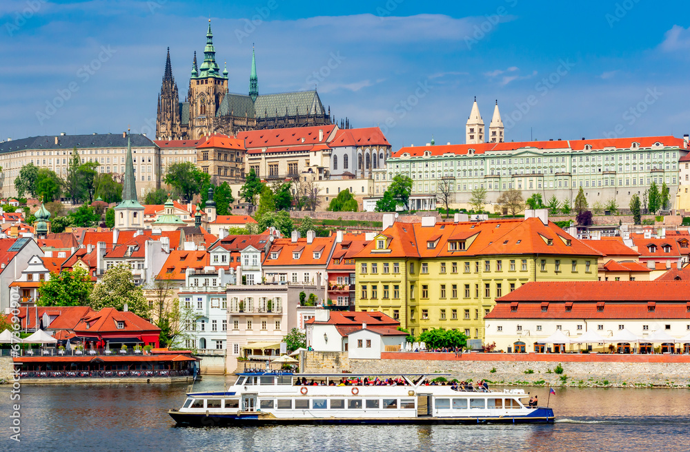 Obraz premium Lesser town (Mala Strana) cityscape with Prague Castle and cruise boat on Vltava river, Czech Republic