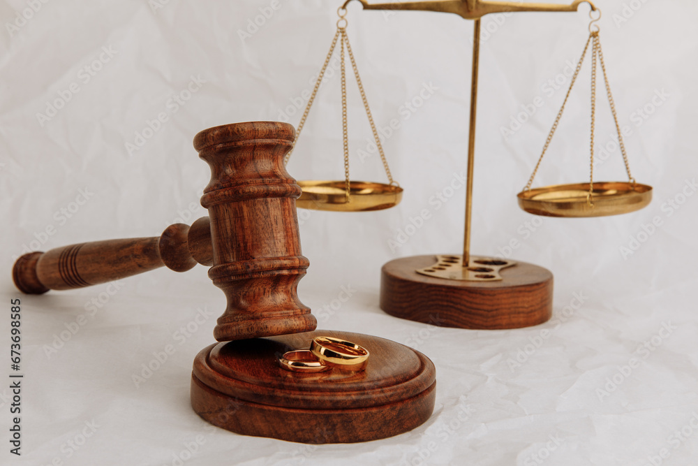 Judge's gavel with rings and scales on light background Judge's gavel with rings and scales on light background