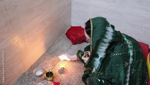 indian women doing holy rituals at home for children's wellbeing from different angle on the occasion of jitiya vrat or nirjala vrat in india. photo