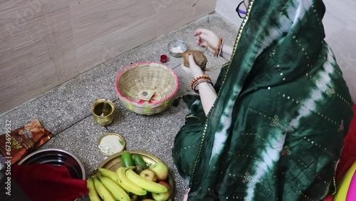 indian women doing holy rituals at home for children's wellbeing from different angle on the occasion of jitiya vrat or nirjala vrat in india. photo