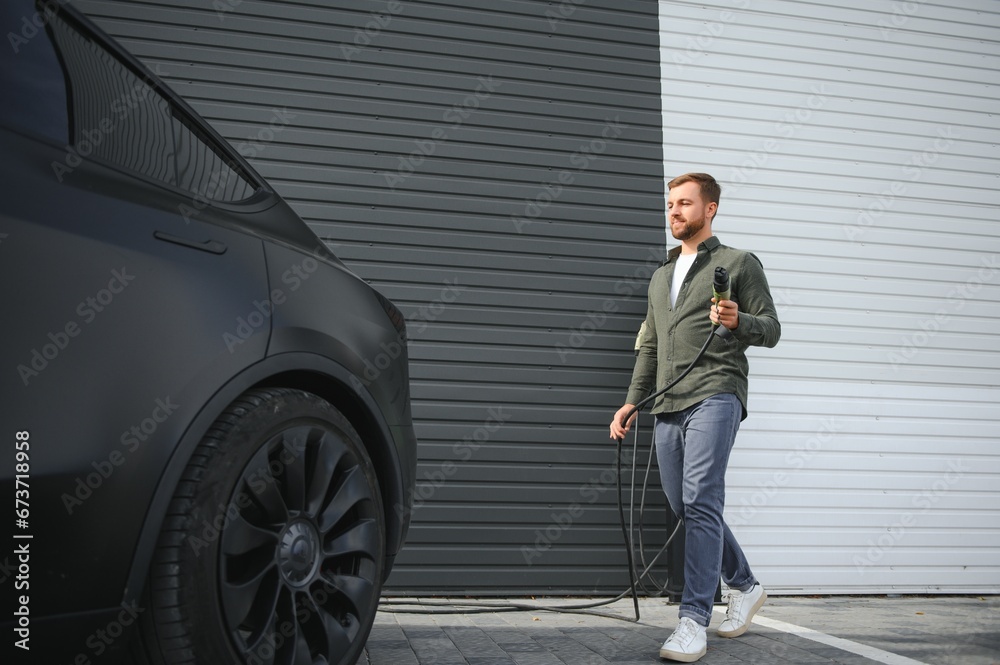 a man charges an electric car