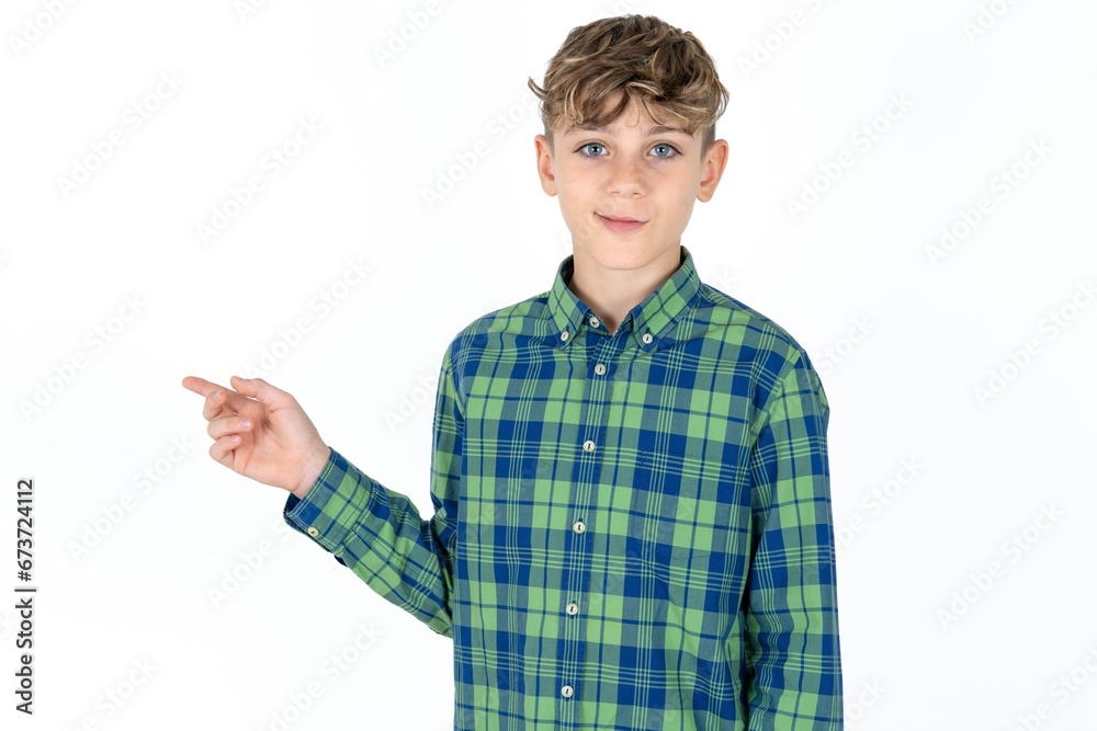 Positive caucasian kid boy wearing plaid shirt with satisfied expression indicates at upper right corner shows good offer suggests to click on link Positive caucasian kid boy wearing plaid shirt with satisfied expression indicates at upper right corner shows good offer suggests to click on link