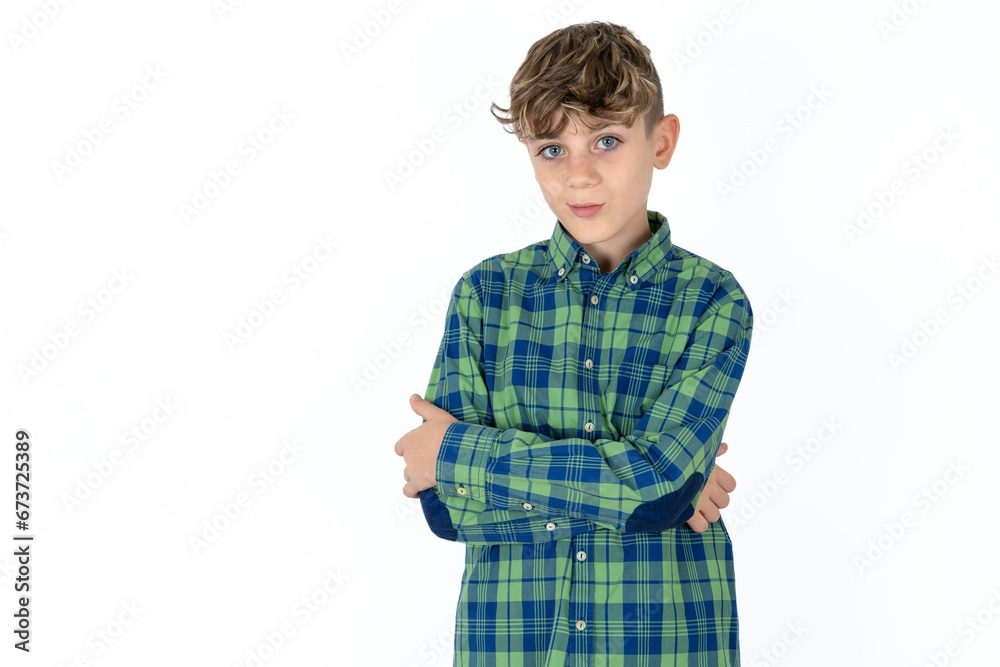 Confident caucasian kid boy wearing plaid shirt with arms crossed looking to the camera Confident caucasian kid boy wearing plaid shirt with arms crossed looking to the camera