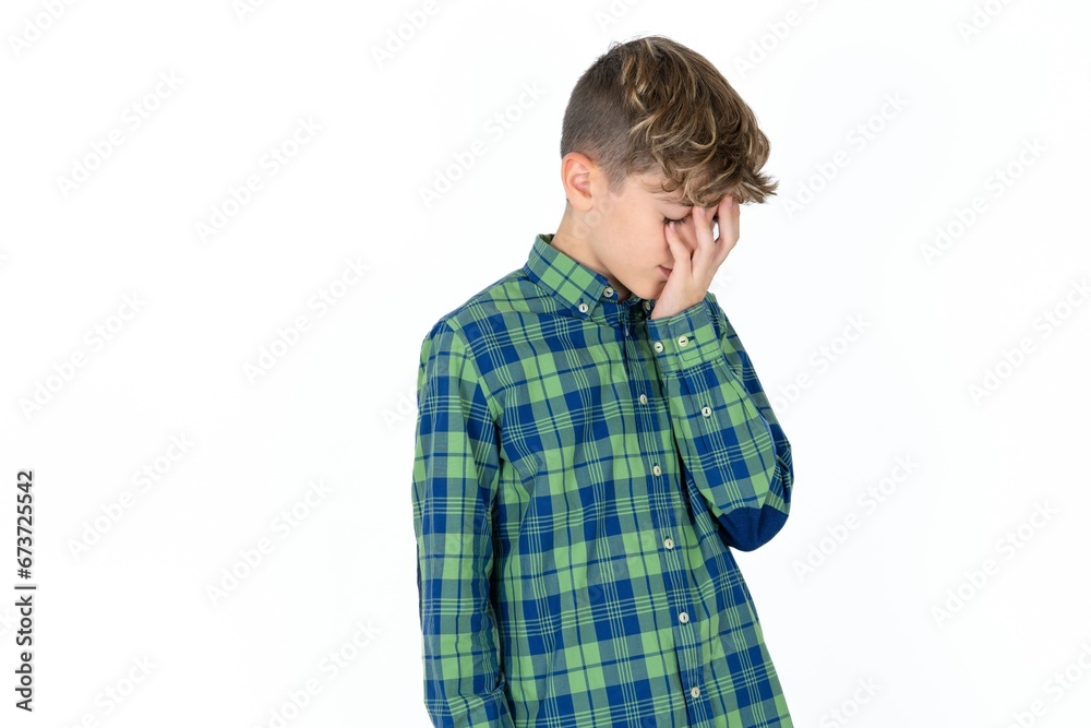 caucasian kid boy wearing plaid shirt with sad expression covering face with hands while crying. Depression concept. caucasian kid boy wearing plaid shirt with sad expression covering face with hands while crying. Depression concept.