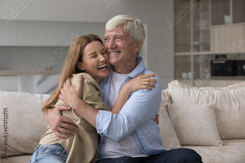 Happy caring loving old daddy hugging adult daughter child, smiling, giving comfort, support, sympathy. Woman congratulating dad on fathers day, enjoying meeting, warm relationship