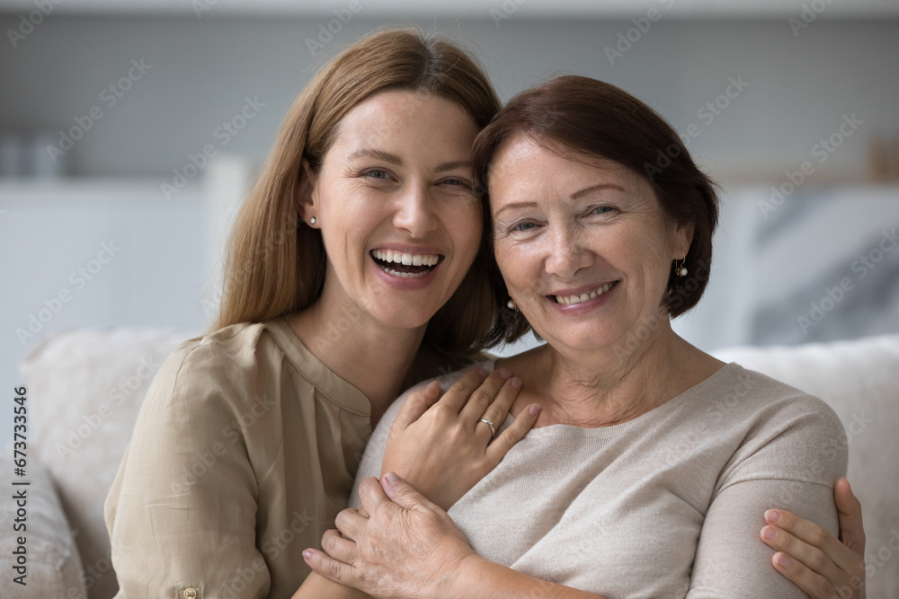 Happy cheerful older retired mom hugging joyful adult child with adoration, love, warmth, tightening daughter, smiling, laughing, feeling affection, tenderness, enjoying motherhood, mothers day
