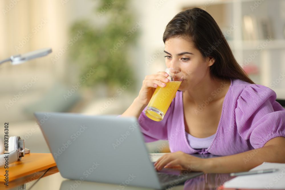 Student e-learning drinking orange juice Student e-learning drinking orange juice