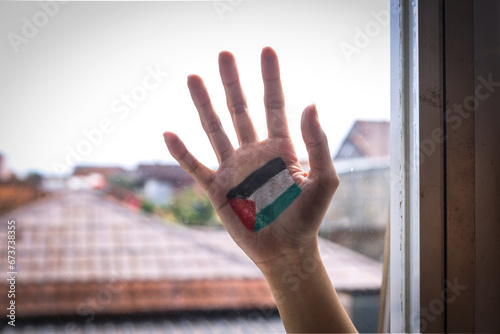 Hand painted with Palestinian flag behind the window. Freedom and colonialism concept