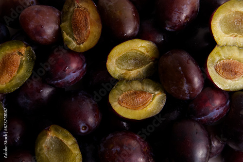 Ripe plums with drops laid out on the surface as a background close-up
