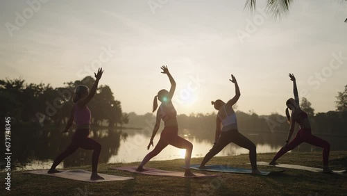 Group of Asian women in sportswear stretching and relax during yoga class in city park in Sunlight,Outdoor Activity and Sports Apparel Concept. photo