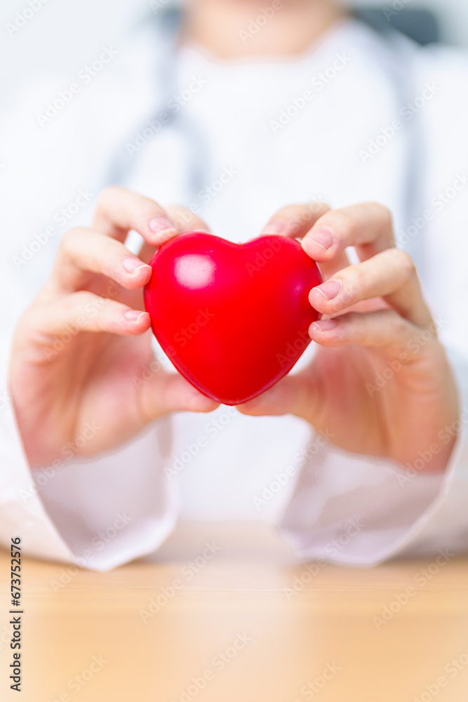 Doctor hand holding red heart shape in hospital. love, donor, world heart day, world health day, CSR donation and Insurance concepts Doctor hand holding red heart shape in hospital. love, donor, world heart day, world health day, CSR donation and Insurance concepts